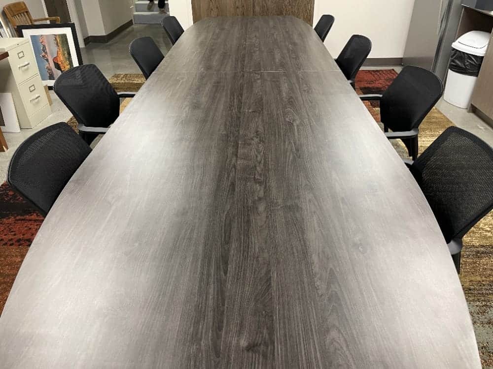 Long conference table with black chairs.